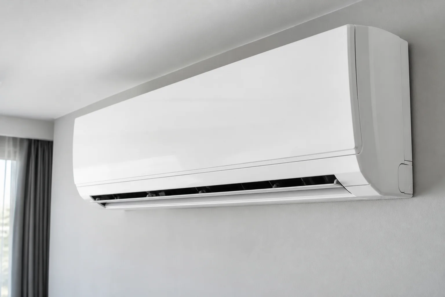 Ar-condicionado split branco instalado em parede clara